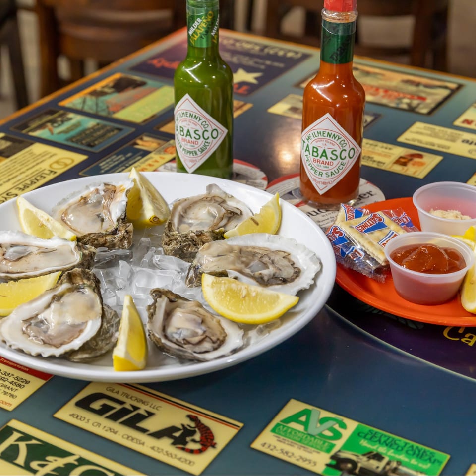 Half dozen oysters on ice with lemon and cocktail sauce.