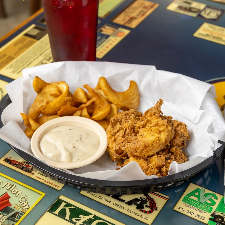 Chicken strips with potato wedges and cream gravy.