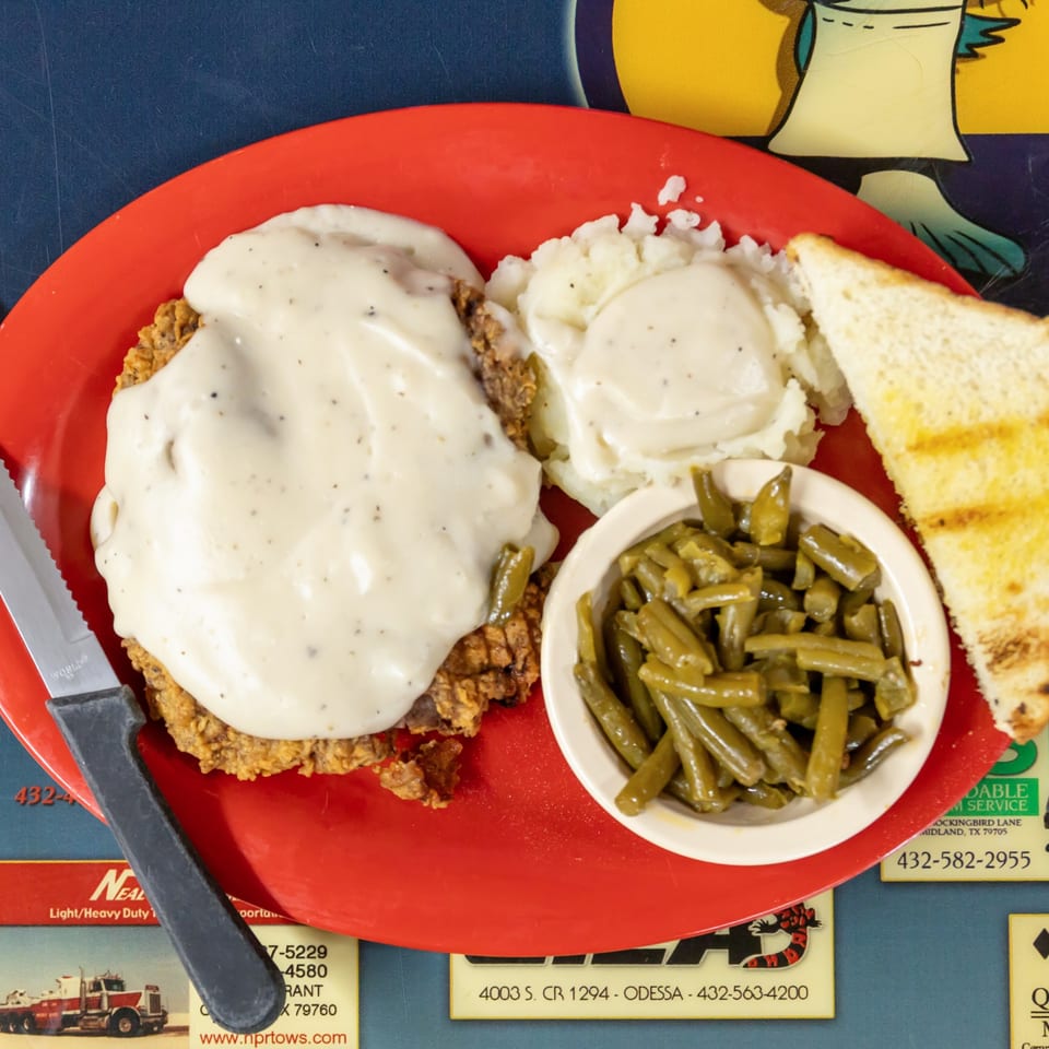 Chicken fried steak with cream gravy and Southern sides.